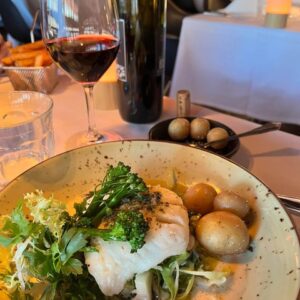 Fiskeret med grønt, kartofler og rødvin på restaurant