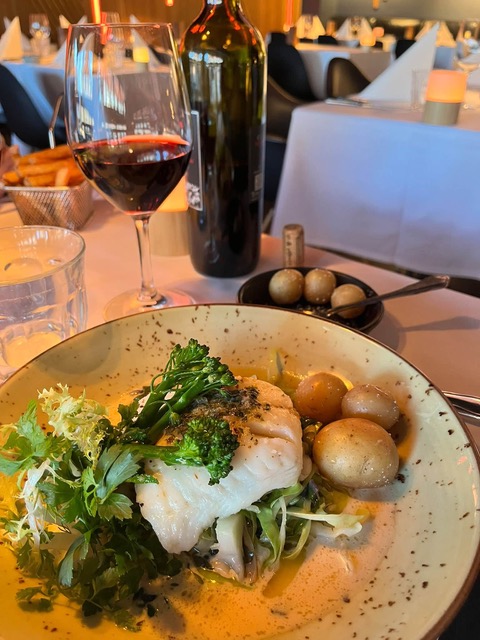 Fiskeret med grønt, kartofler og rødvin på restaurant